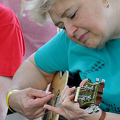 A woman plays a ukulele