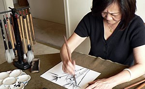 Master artist Diana Meng works on a traditional Chinese watercolor painting of bamboo.