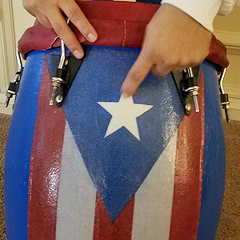 Pedro Antonetty shows a drum that he made, painted with a Puerto Rican flag